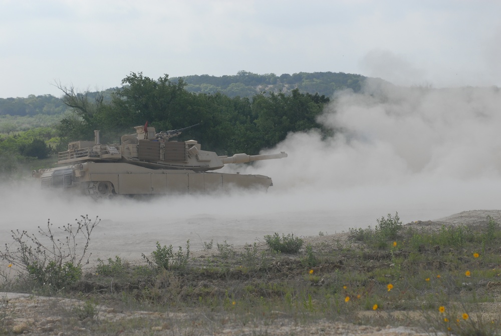 Soldiers from Delta Company, 1-145th Armored Regiment, fire rounds from an M1A1 Abrams tank