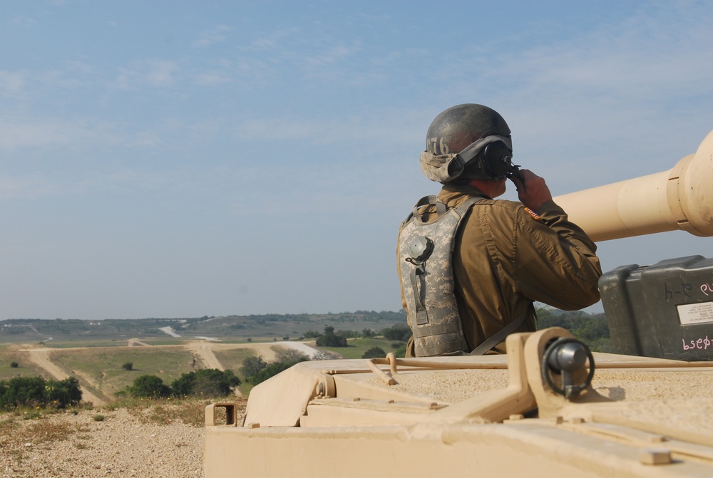 Sgt. 1st Class Daniel Fortney, a platoon sergeant with Charlie Company, 1-145th Armored Regiment, assists in bore sighting the weapon systems of an M1A1 Abrams tank