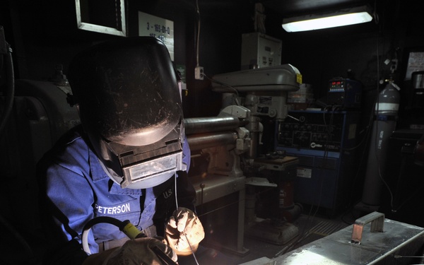 USS George Washington sailor at work in shipfitter shop