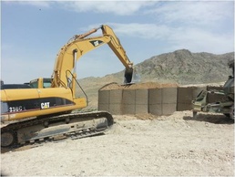Afghan National Army Engineers compact Hesco barriers for the perimeter of Combat Outpost Altamuur