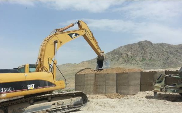 Afghan National Army Engineers compact Hesco barriers for the perimeter of Combat Outpost Altamuur