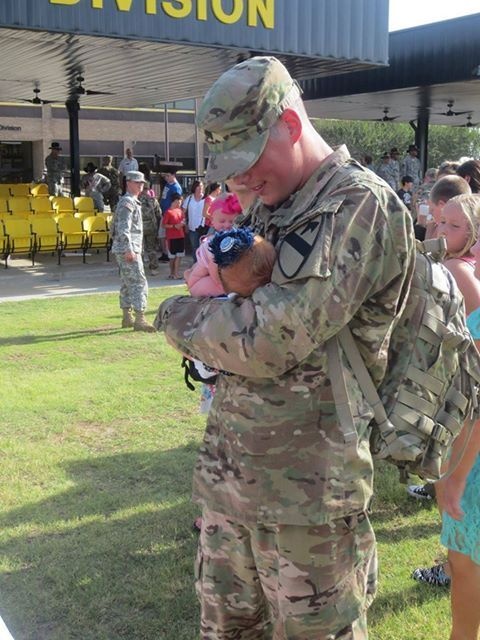 Redeployed soldier meets his week-old daughter