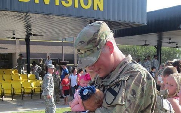 Redeployed soldier meets his week-old daughter