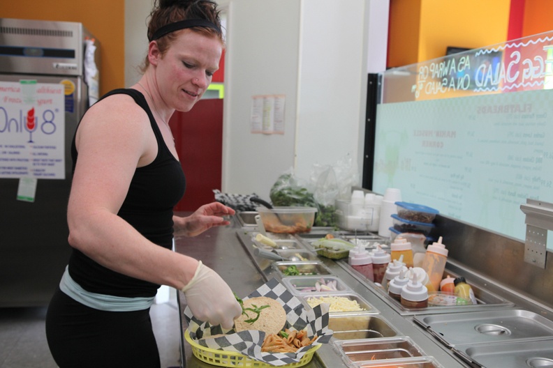 Evonne White, Clean Eatz co-owner, prepares a vegetable burger ordered by a customer