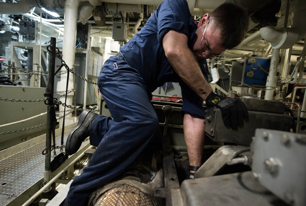 USS Freedom sailor works on diesel engine