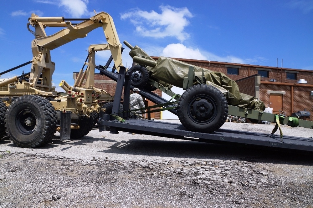 Two Army transport trucks unload cannons in Harrodsburg, Ky. for an August tribute honoring fallen Veterans