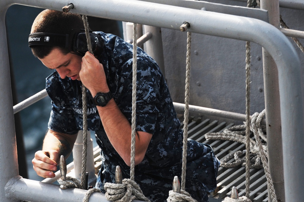 Sailor prepares to lower signal flag