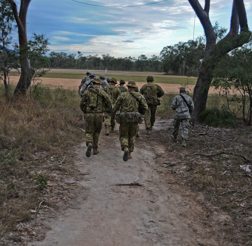 A group of US and Australian soldiers escort Australian Army Major General to an airfield