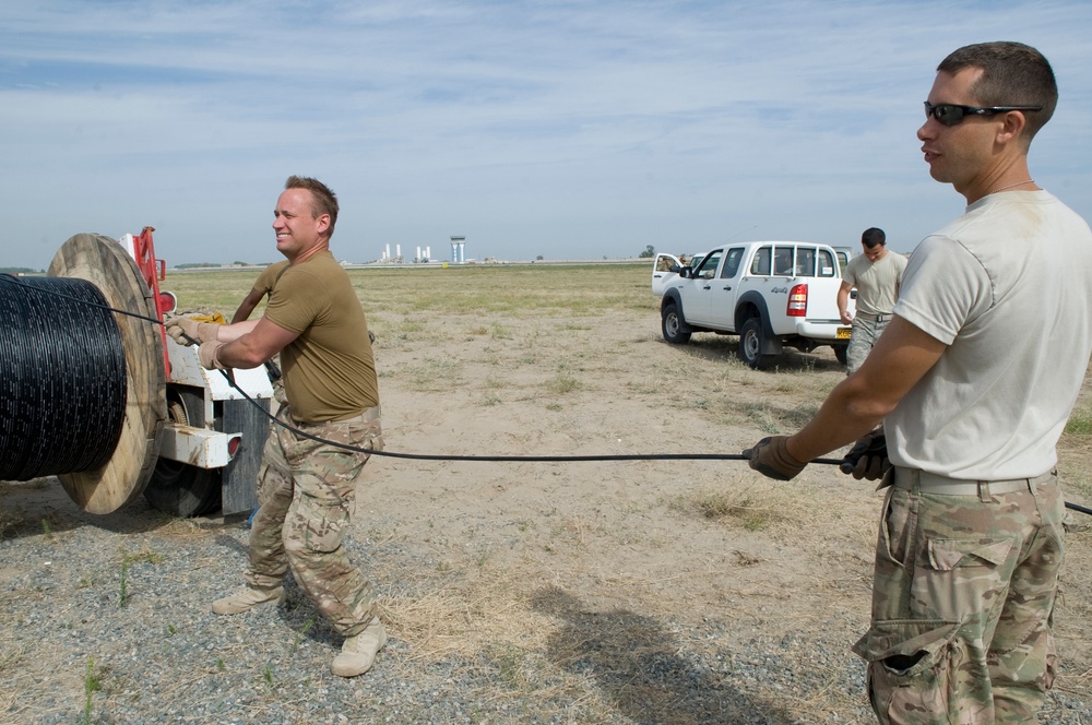 Airmen feed cable under flightline for new tower