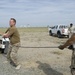 Airmen feed cable under flightline for new tower