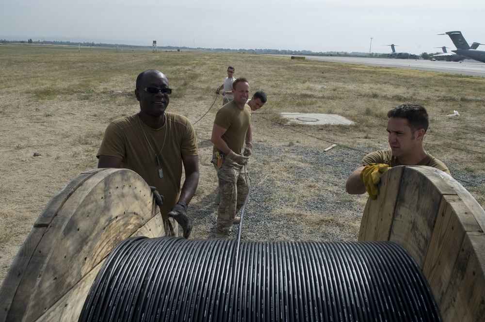 Airmen feed cable under flightline for new tower