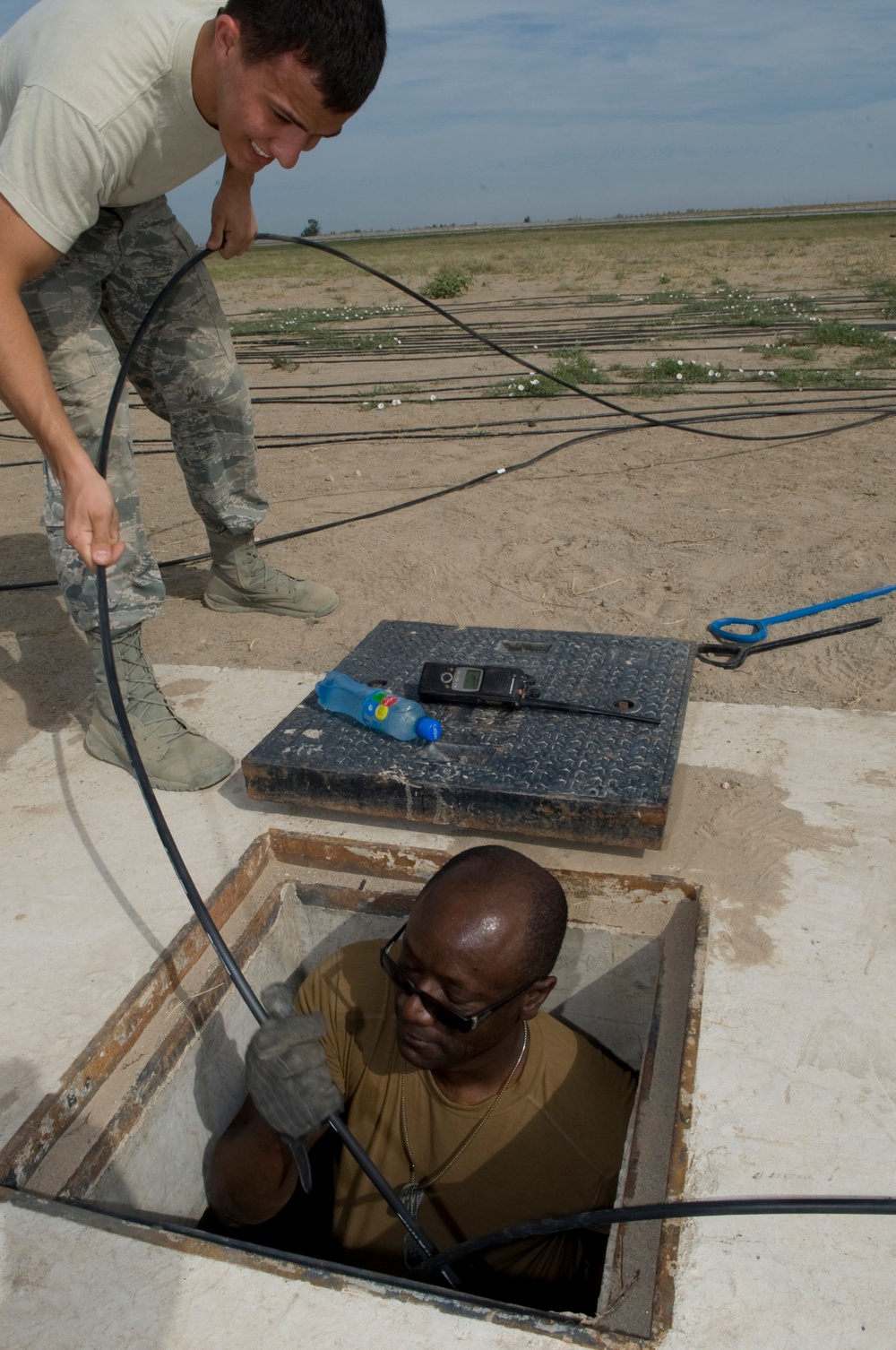 Airmen feed cable under flightline for new tower