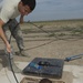 Airmen feed cable under flightline for new tower