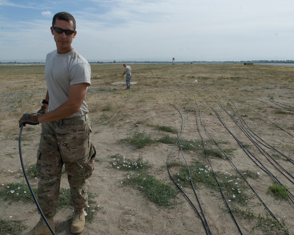 Airmen feed cable under flightline for new tower