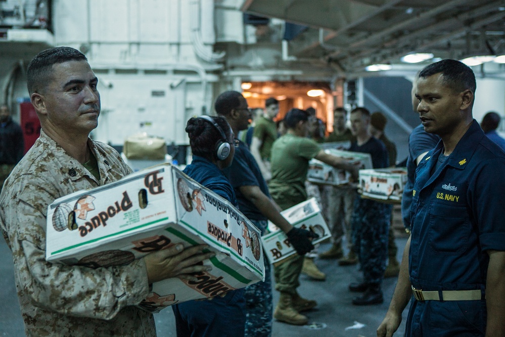 Marines and Sailors work together during re-supply at sea