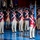 Lt. Gen. Dana Kyle Chipman retirement ceremony A formal military ceremonial performance featuring soldiers dressed in 18th-century American Revolutionary War-era uniforms. The performers are arranged in formation on what appears to be an indoor stage or arena floor, with one central figure carrying a flag on a pike. The scene resembles a U.S. Army Old Guard or similar ceremonial unit drill performance.