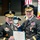 Lt. Gen. Dana Kyle Chipman retirement ceremony Two U.S. Army general officers in dress uniforms are jointly holding a certificate from The United States of America, appearing to be a Distinguished Service Medal award presentation. The officer on the left has a name tag reading 'DEMPSEY' and wears four-star general insignia. The ceremony takes place in a formal military setting with flags and a historical uniform mannequin visible in the background.