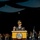 Lt. Gen. Dana Kyle Chipman retirement ceremony A senior U.S. Army officer in full dress uniform is delivering a speech at a formal military ceremony from a wooden podium bearing the Department of the Army seal. The officer is gesturing with one raised finger while speaking into microphones. Behind the speaker, rows of uniformed soldiers stand at attention alongside military color guard bearers holding flags.