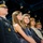 Lt. Gen. Dana Kyle Chipman retirement ceremony A formal military ceremony featuring uniformed officers and civilians standing together on what appears to be a stage or platform. The group includes at least two military personnel in dress uniforms and several civilians, likely family members, suggesting a promotion, retirement, or award ceremony. The subjects are posed in a line, facing forward toward an unseen audience or focal point.