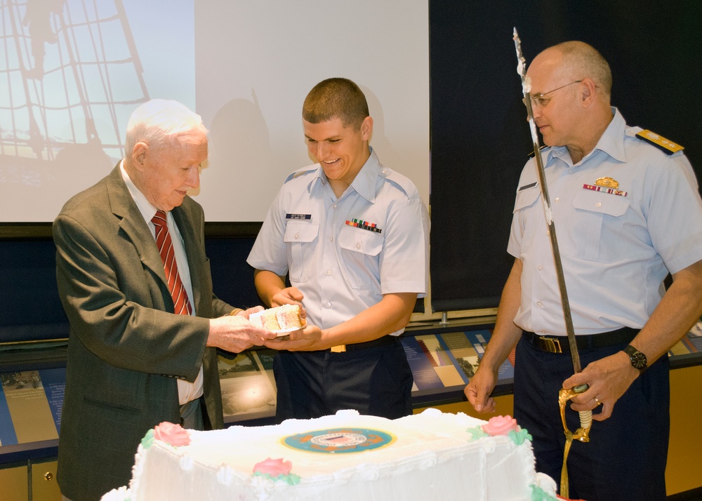 Robert Devaney passes Fireman Jordan Gottfried a piece of cake at a ceremony celebrating the US Coast Guard's 223rd birthday at the Armed Forces Retirement Home in Washington, DC