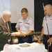 Robert Devaney passes Fireman Jordan Gottfried a piece of cake at a ceremony celebrating the US Coast Guard's 223rd birthday at the Armed Forces Retirement Home in Washington, DC