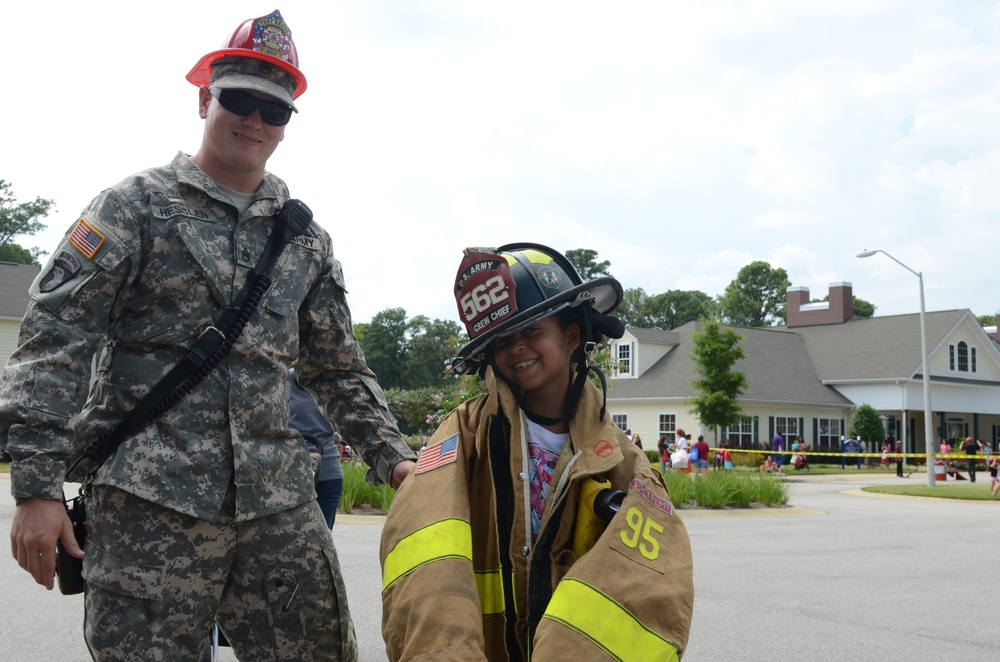 Firefighter exchanges hats with a family member during National Night Out Safety Fair