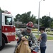 Firefighter helps family member gear up during safety fair
