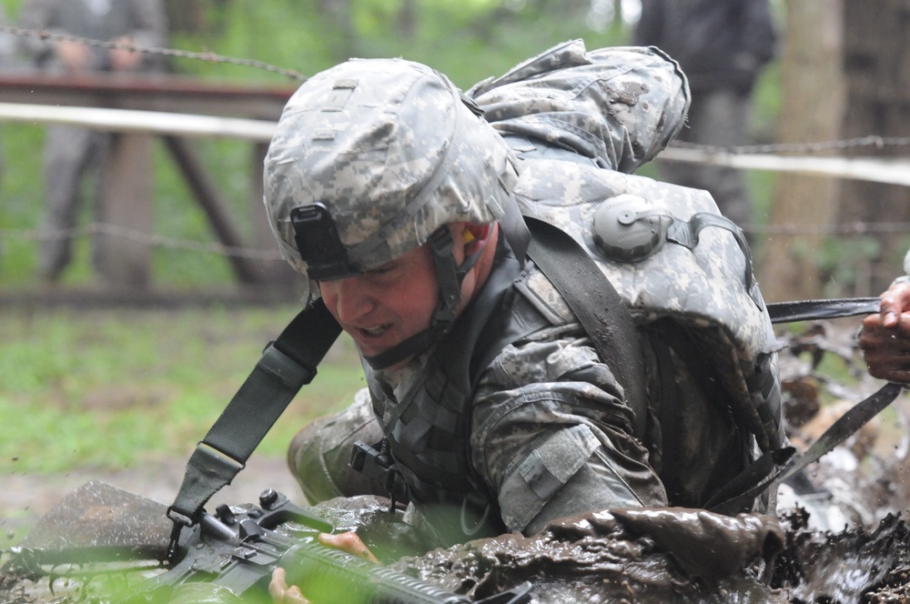 OSW soldier low crawls through mud and under barbed wire