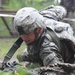 OSW soldier low crawls through mud and under barbed wire