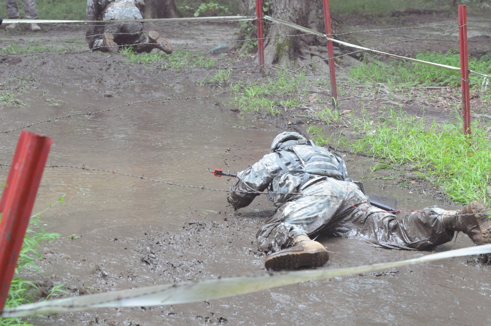 OSW soldier low crawls through mud with weapon