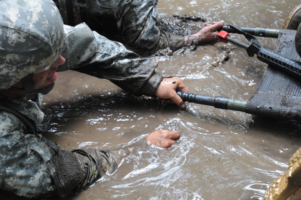 OSW soldiers carry litter through mud