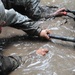 OSW soldiers carry litter through mud