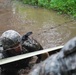 OSW soldier low crawls through the mud and under barbed wire