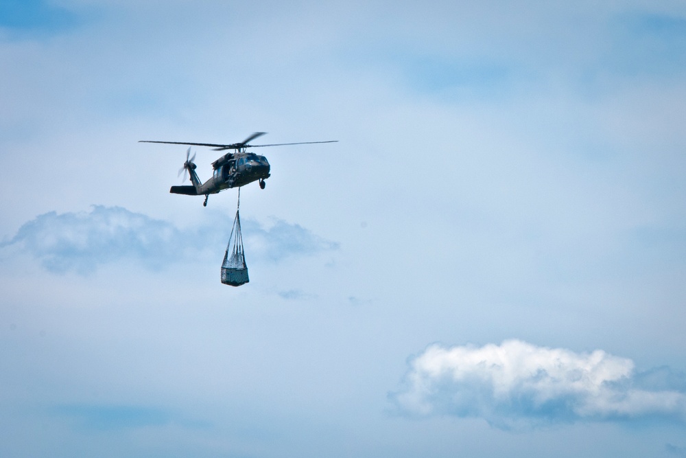 UH-60 Black Hawk lifts supplies through the sky during Vibrant Response 13-2
