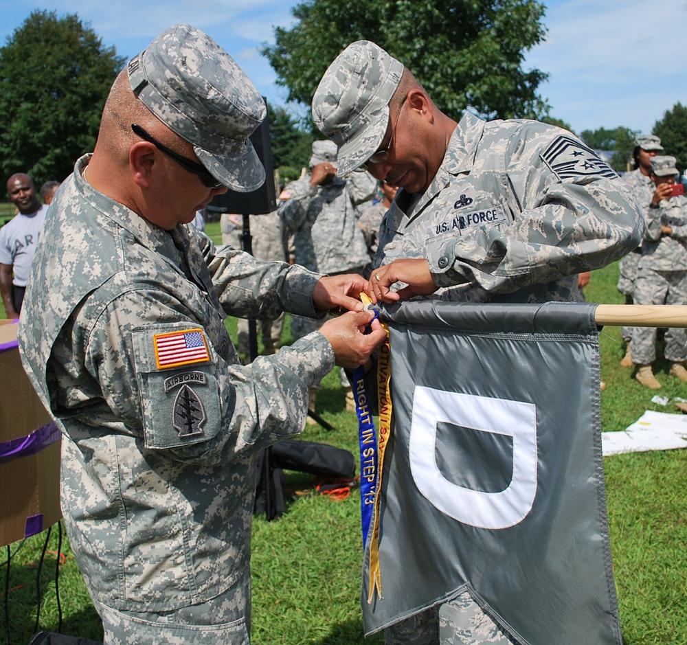 OSW US Army CSM Sablan and US Air Force Chief Master Sgt. Robinson award a streamer to Delta company