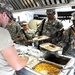 Food service specialists serve chow