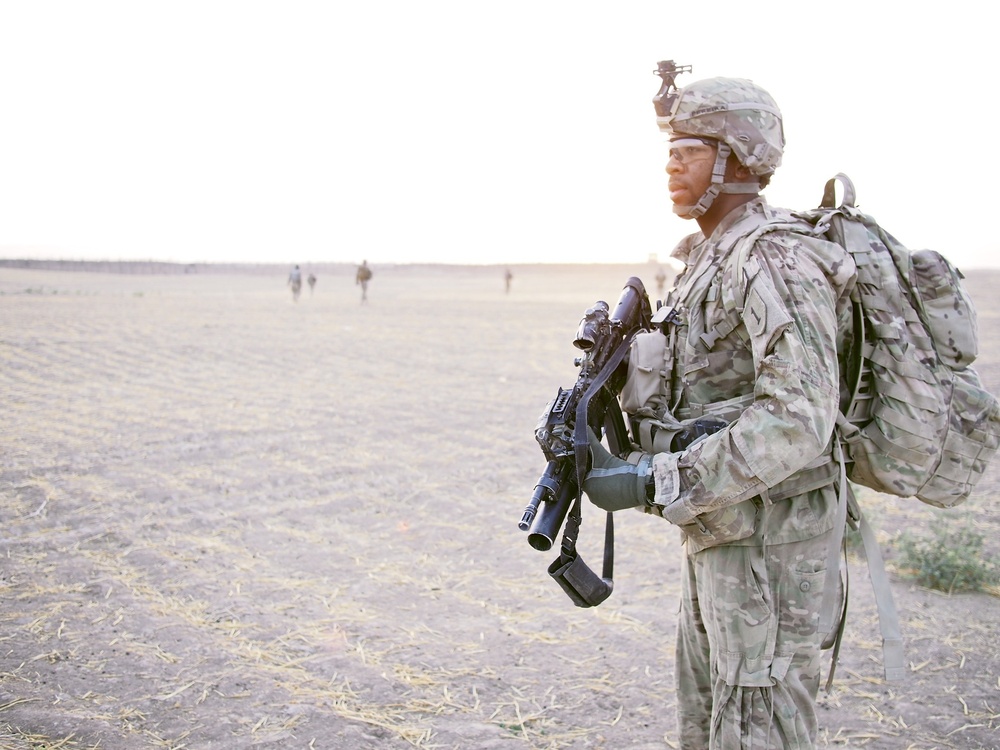 Pfc. Pereira scans to the north while on a dismounted security patrol outside of FOB Kunduz