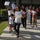 81st Civil Affairs Battalion welcome home ceremony A military homecoming event showing families and children gathered outside a building, holding welcome signs and American flags. The crowd appears to be waiting to greet returning service members, with signs expressing love and anticipation. The scene takes place outside what appears to be a military facility marked 'HHC' on the building.