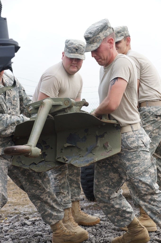 Kentucky soldiers work together to move a 105-millimeter cannon