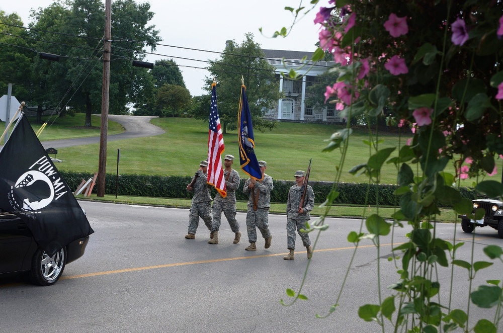 Four soldiers march in a parade honoring military Veterans
