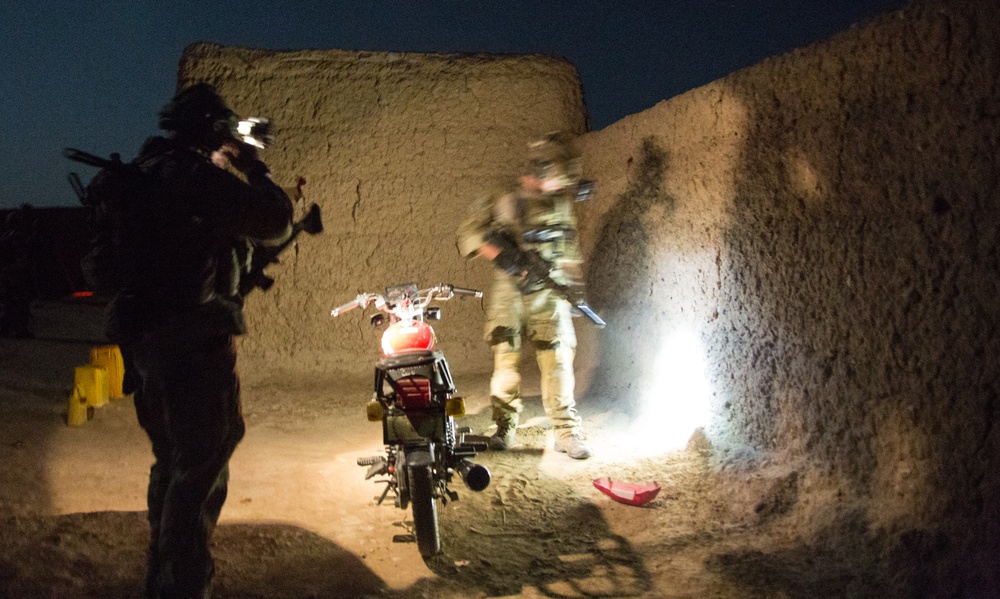 Coalition force members conduct operation in Helmand province
