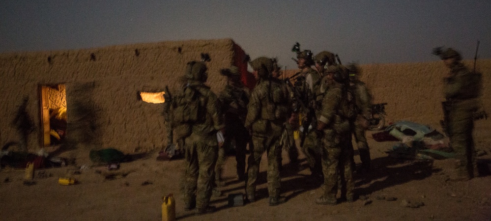 Coalition force members conduct operation in Helmand province