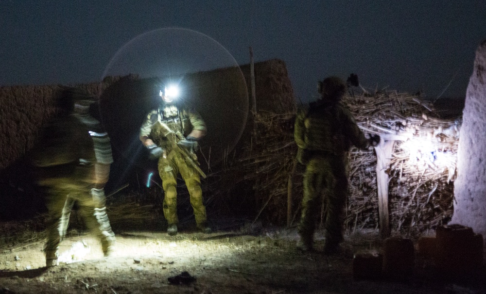 Coalition force members conduct operation in Helmand province