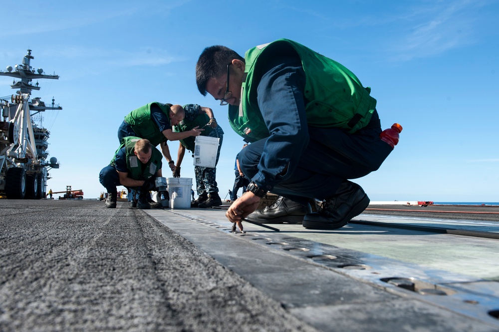 Sailors perform maintenance on flight deck