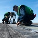 Sailors perform maintenance on flight deck