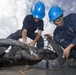 USS Mason sailors attach hook to anchor chain