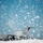 Flurry of foam released at Travis A U.S. Air Force military transport aircraft is parked on a flight line during a heavy snowstorm. The aircraft, identifiable by 'U.S. AIR FORCE' markings on the fuselage, appears to be a C-17 Globemaster III based on its distinctive tail and body shape. Large snowflakes fill the foreground and sky, partially obscuring the aircraft and creating a dramatic winter weather scene.