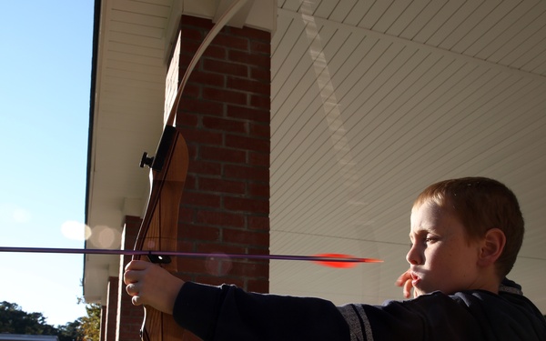Military children learn archery fundamentals