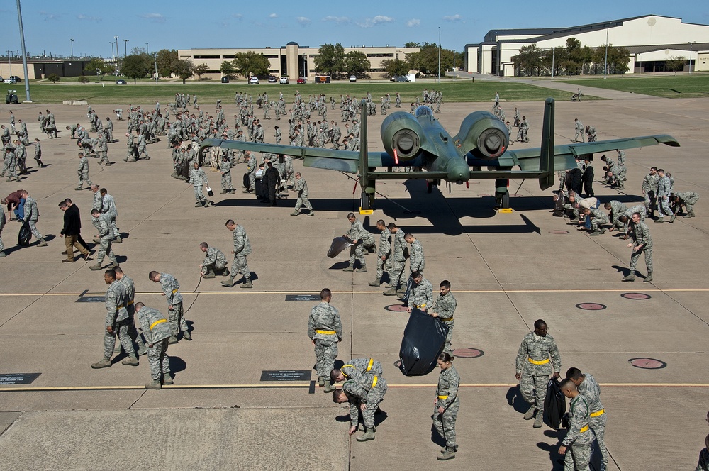 Airman and civilian employees, perform a Foreign Object Debris (FOD) Walk