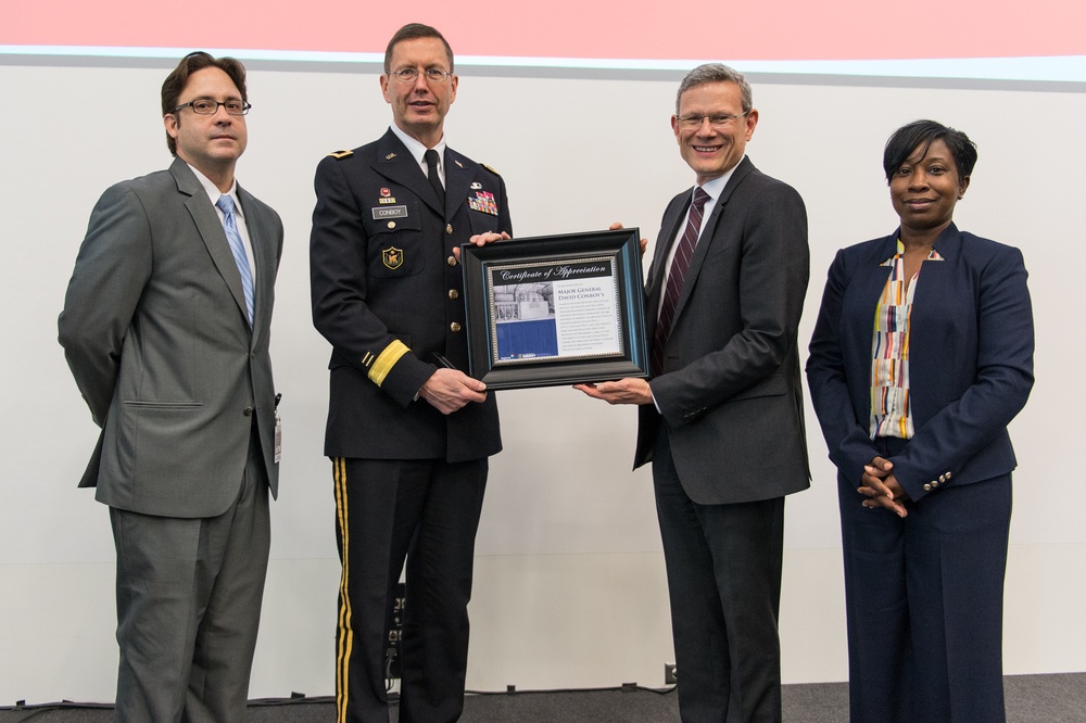 Paul Kerns presents Maj. Gen. David Conboy  a plaque with Alberto Camargo and Andrea Viel